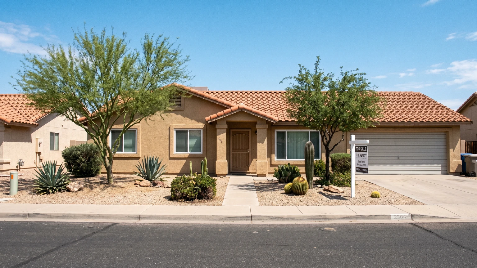 Single-story tan stucco Phoenix ranch home with a FOR SALE sign in the front yard under hard desert sun